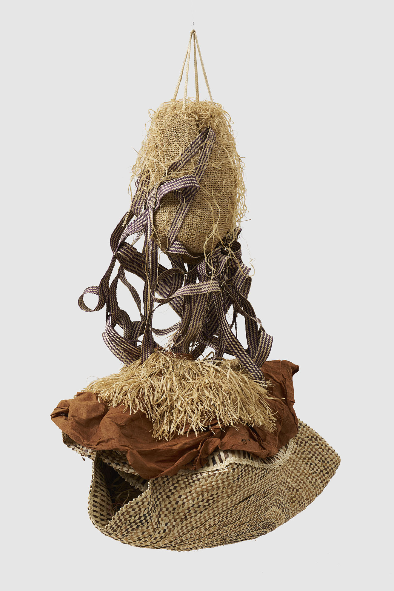 Hanging sculpture made of woven basketry, burlap, raffia, and fabric.