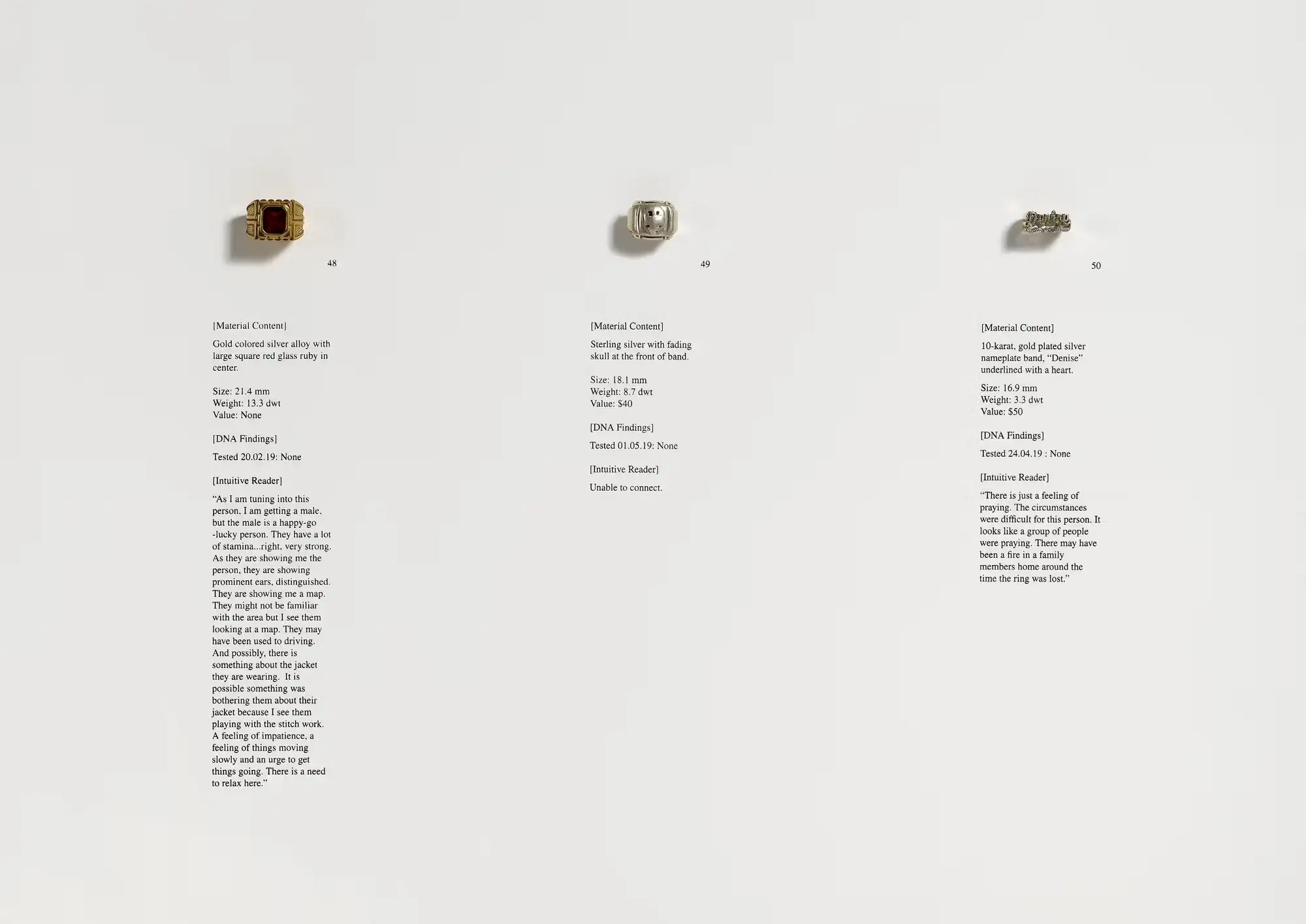 A photograph shows three pieces of jewelry on a plain surface. The first is a gold-colored ring with a square red stone. The second is a sterling silver ring with a skull on the front. The third is a gold nameplate ring that says