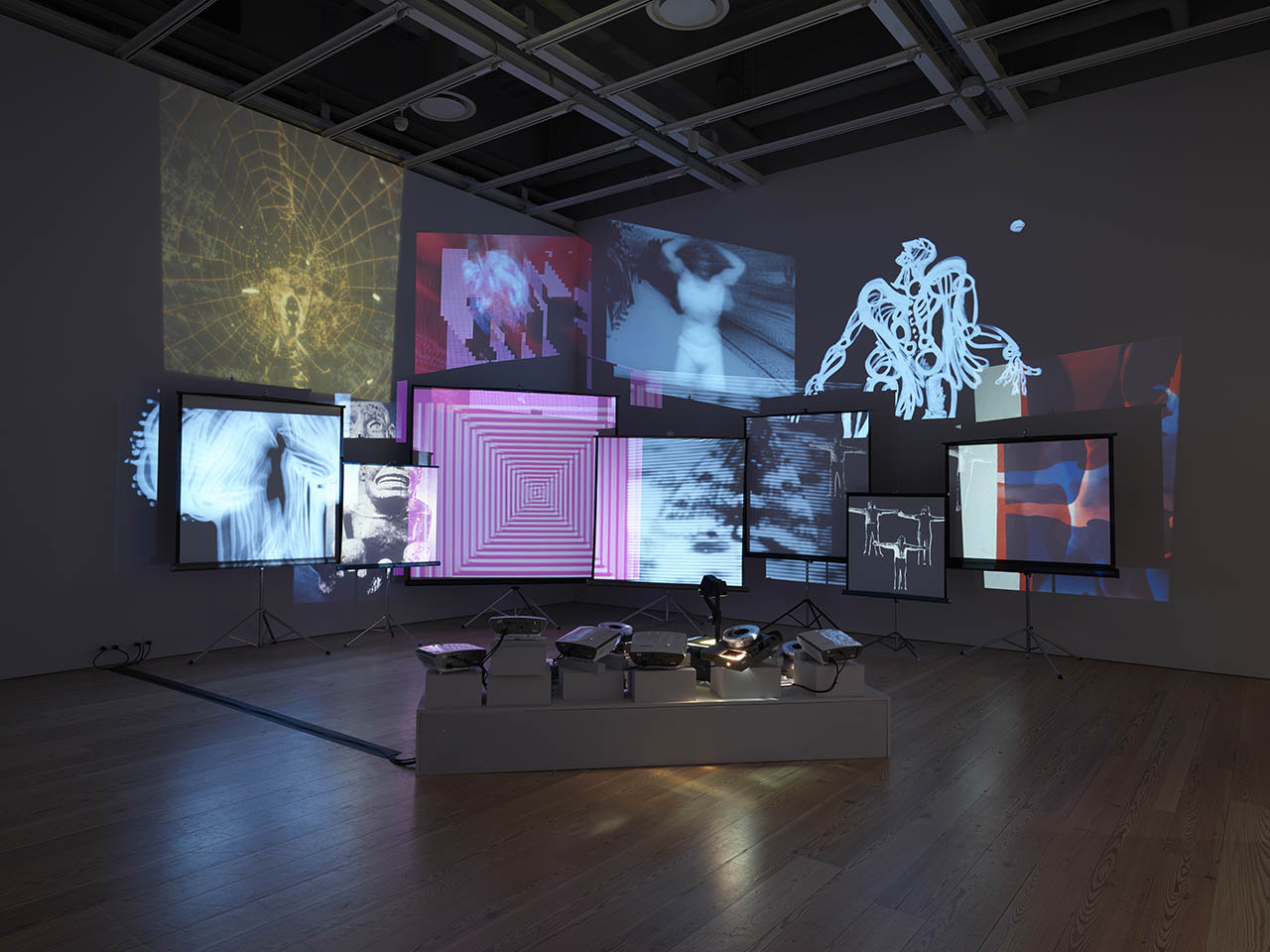Installation view of multiple movie and slide projections in both black and white and color