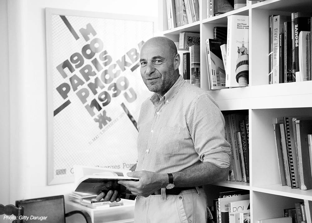 Portait of Jean-Louis Cohen in his home office surrounded by books.