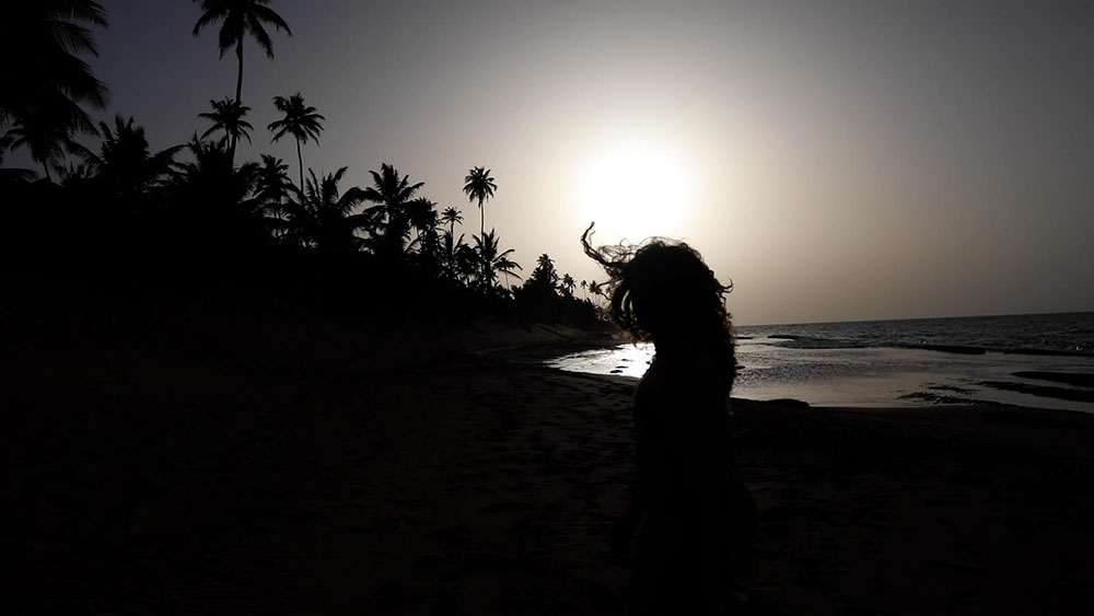 Silhouette of a figure on a beach at dusk.