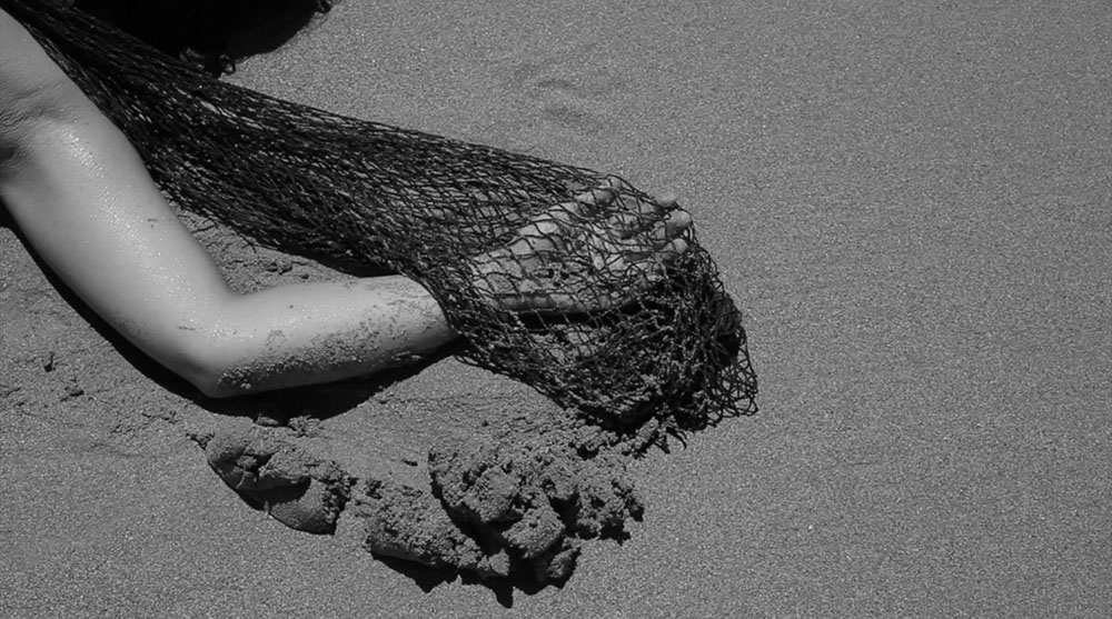 Arm and fishing net on the sand.
